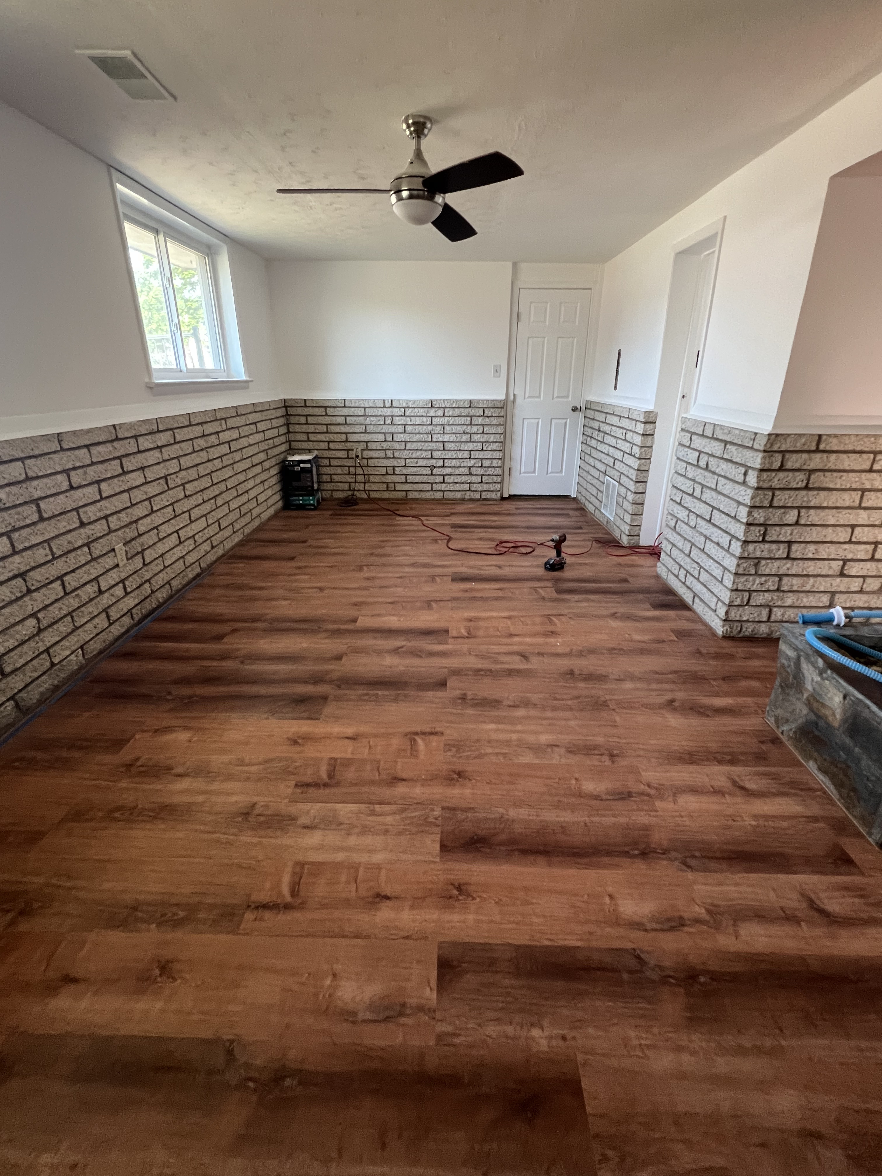 Finished interior remodeling project with wood flooring and brick feature wall
