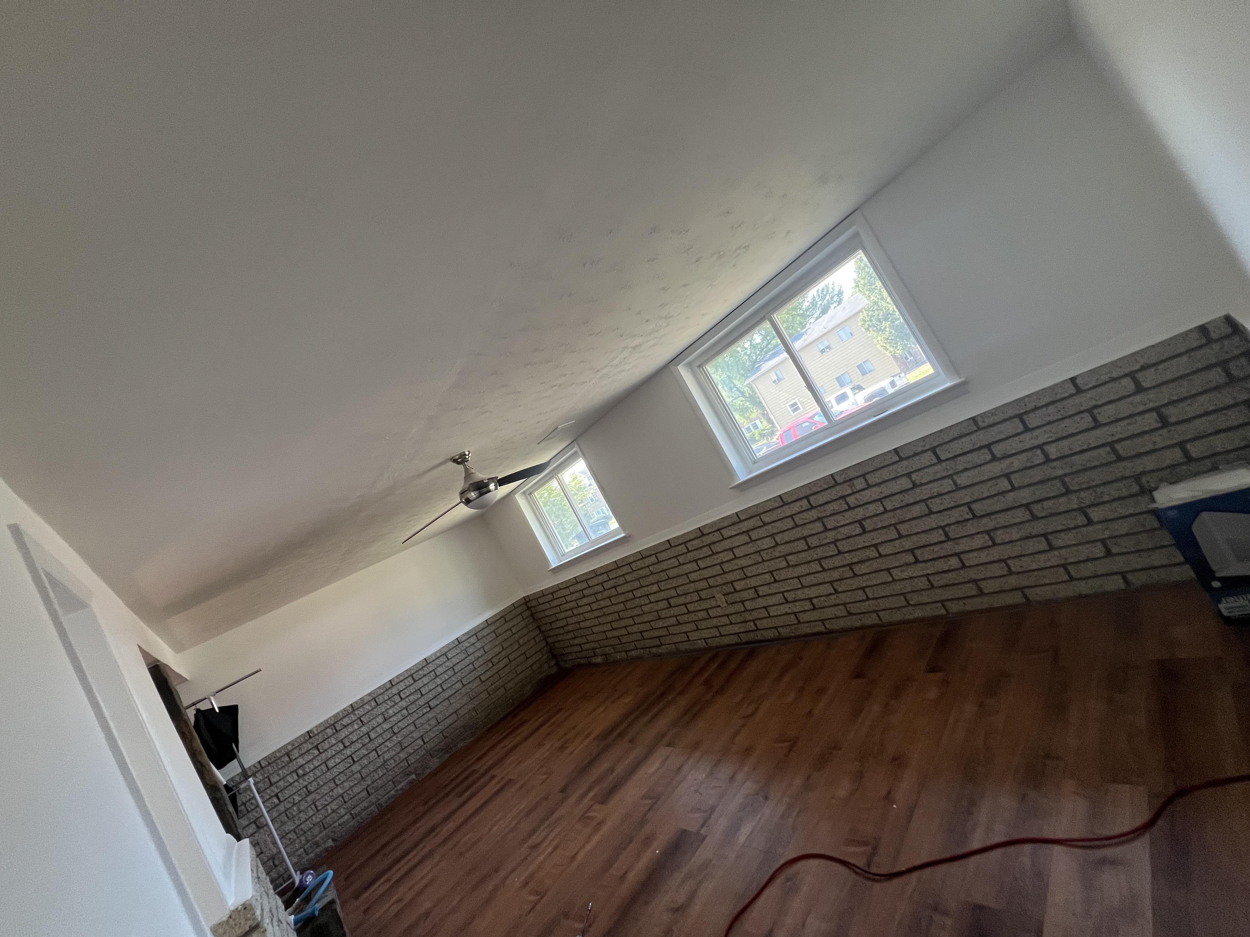 Finished room remodel with brick wall and wood floor